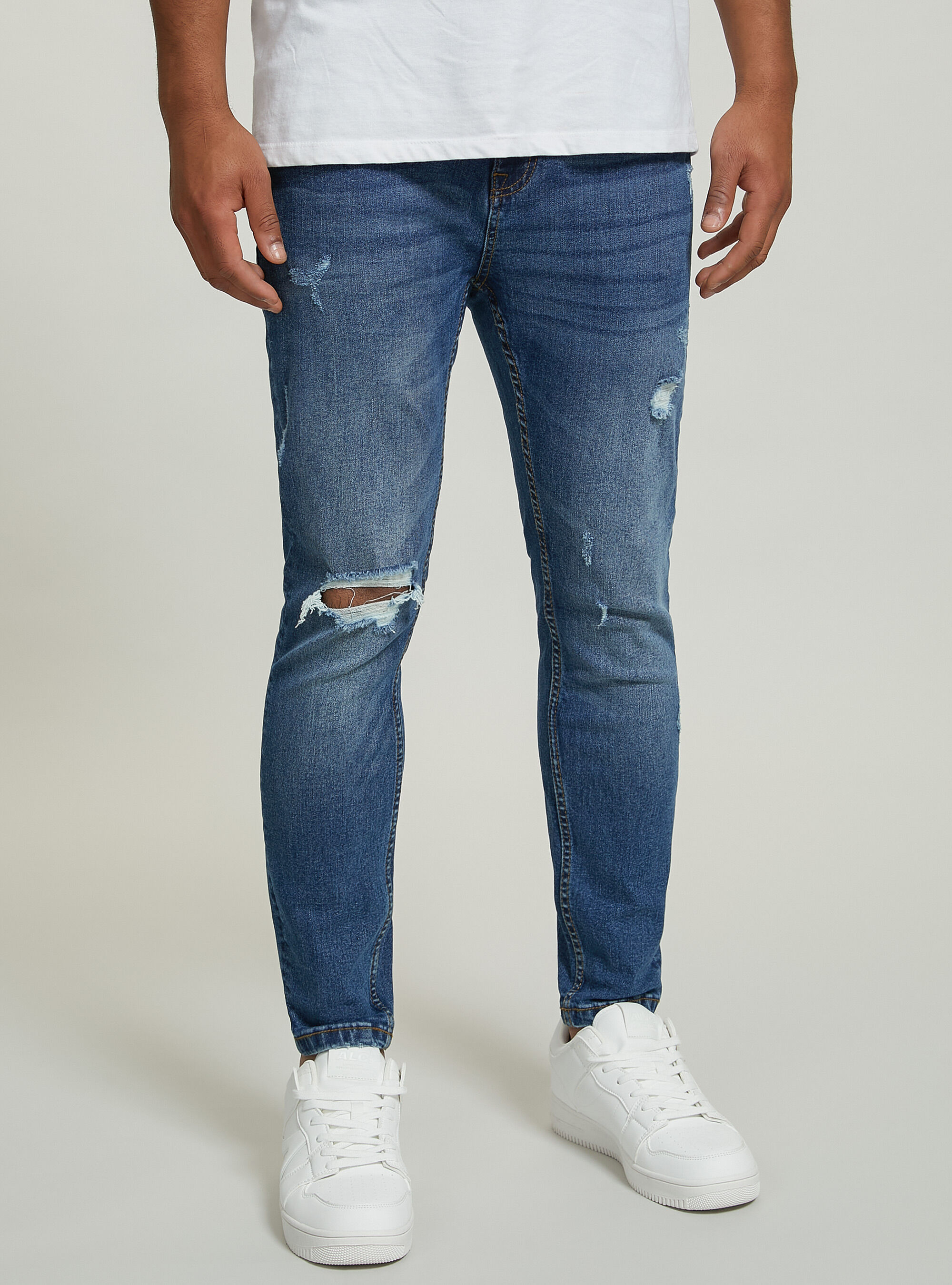 Jeans en denim stretch coupe carotte avec d&eacute;chirures